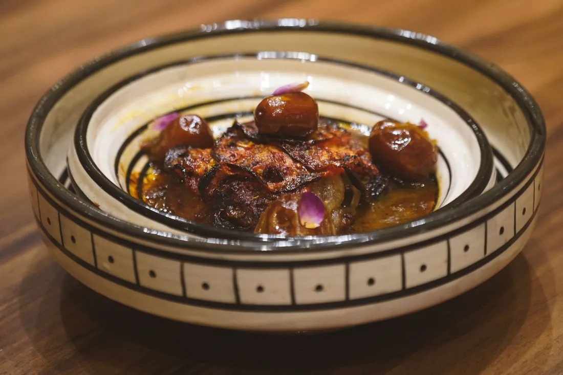 Un plat marocain aux dattes, servi dans un bol en céramique peint