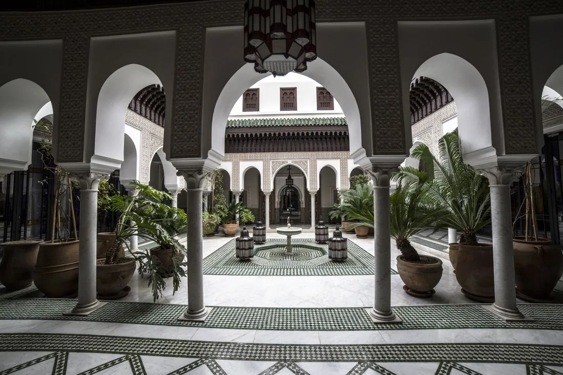 Le patio d’un palais marocain vu à travers des arcs blancs